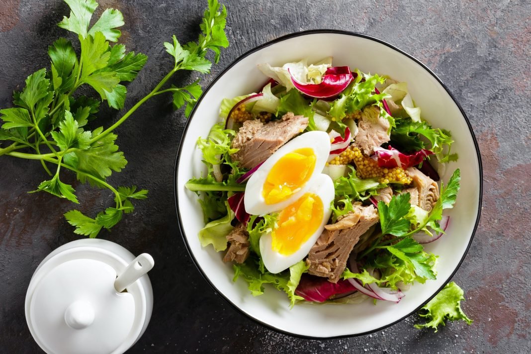 Diet food tuna salad with boiled egg, canned fish, onion and green lettuce